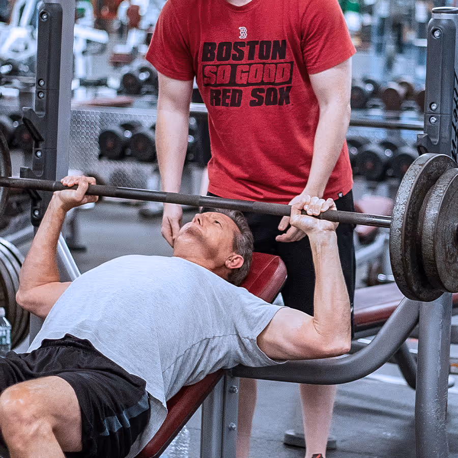 Member bench pressing, assisted by other member.