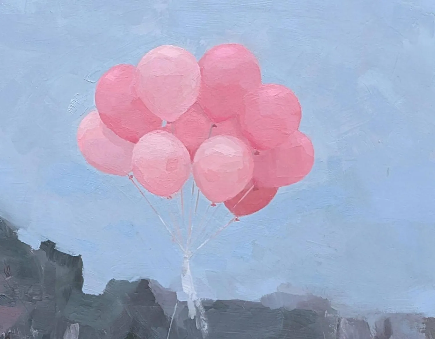 bundle of pink balloons floating against a blue sky with a treeline in background
