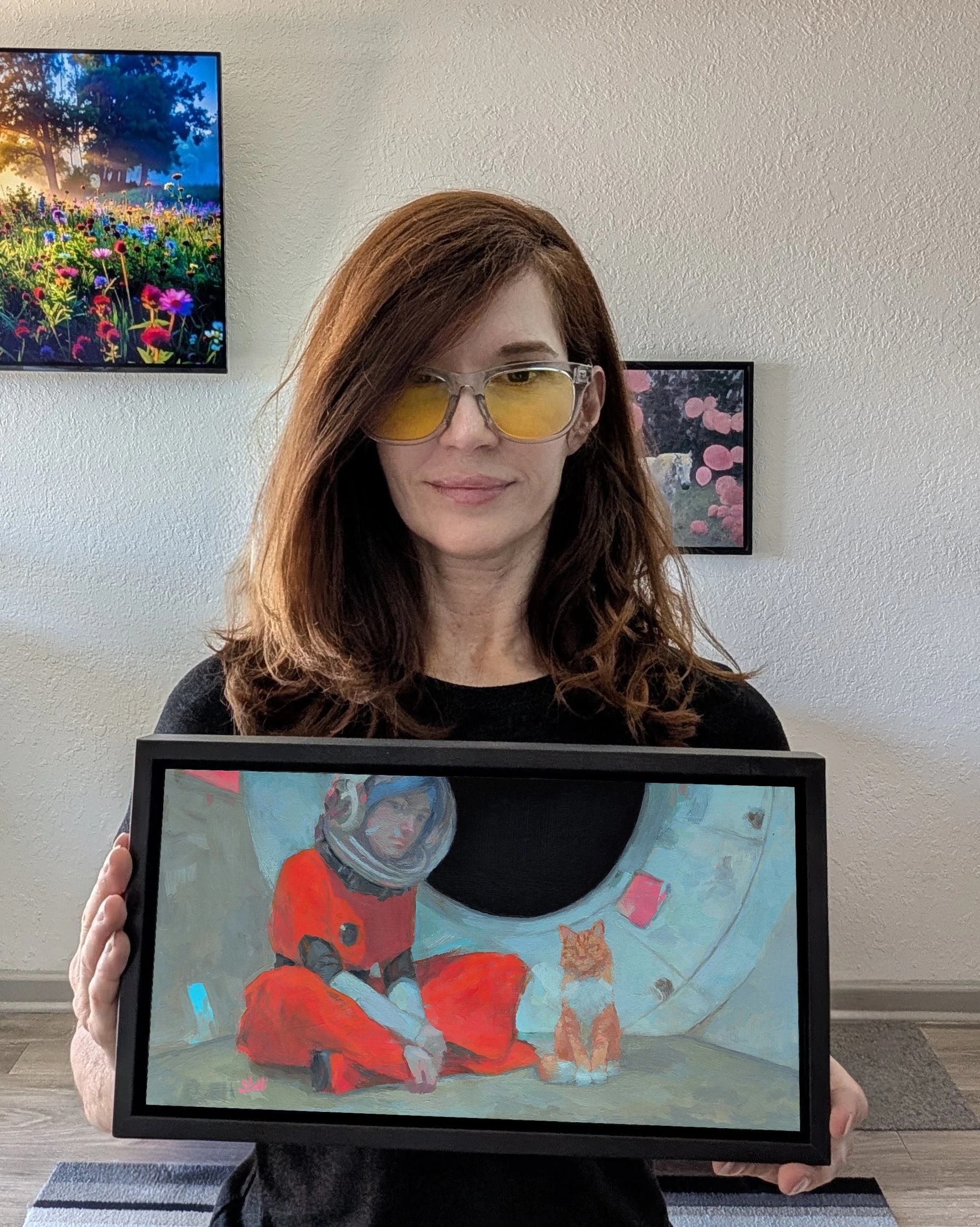the artist holding the framed painting Tiny Heartbeat