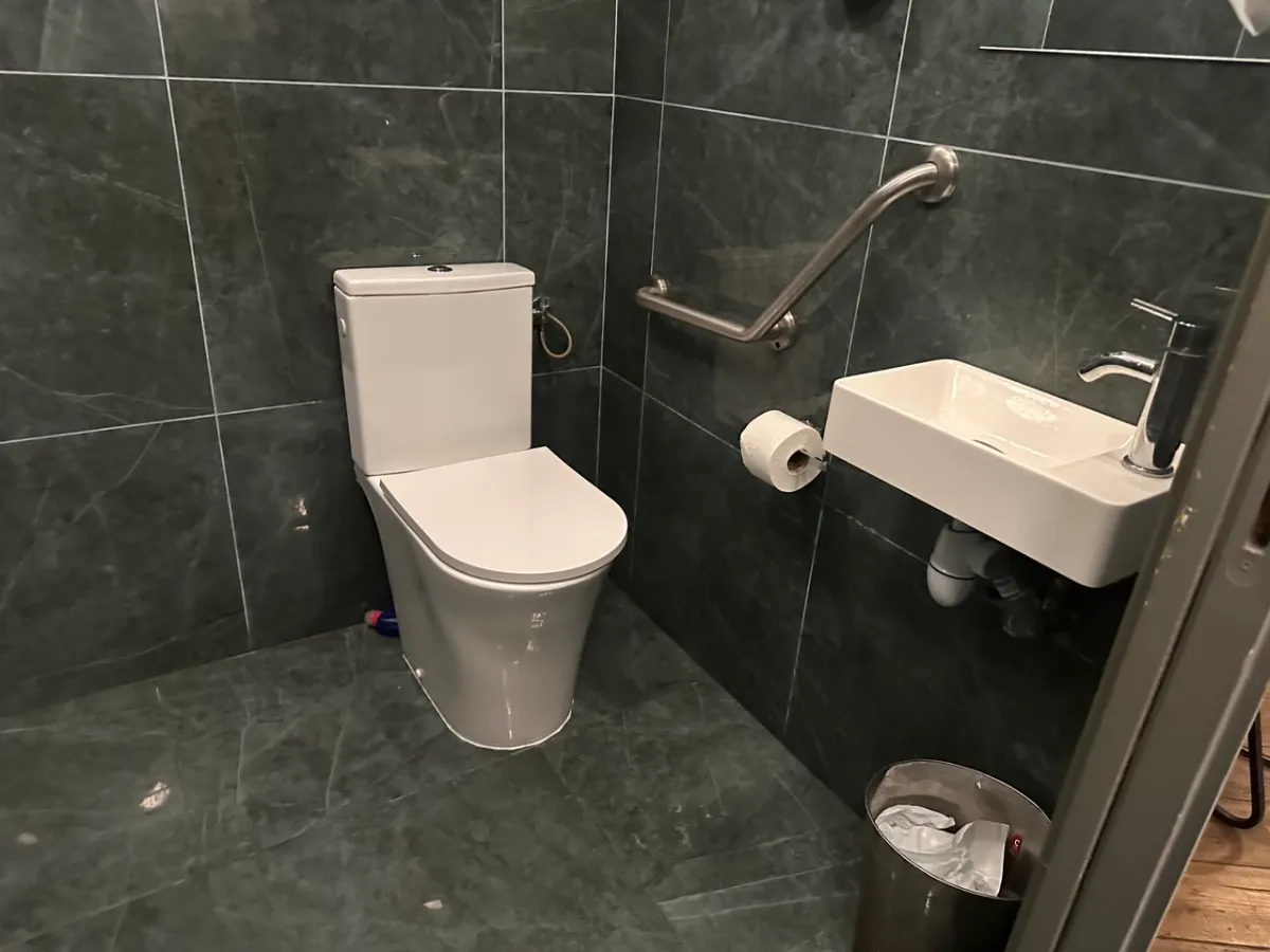 Spacious accessible toilet at Zazza with grab bar.