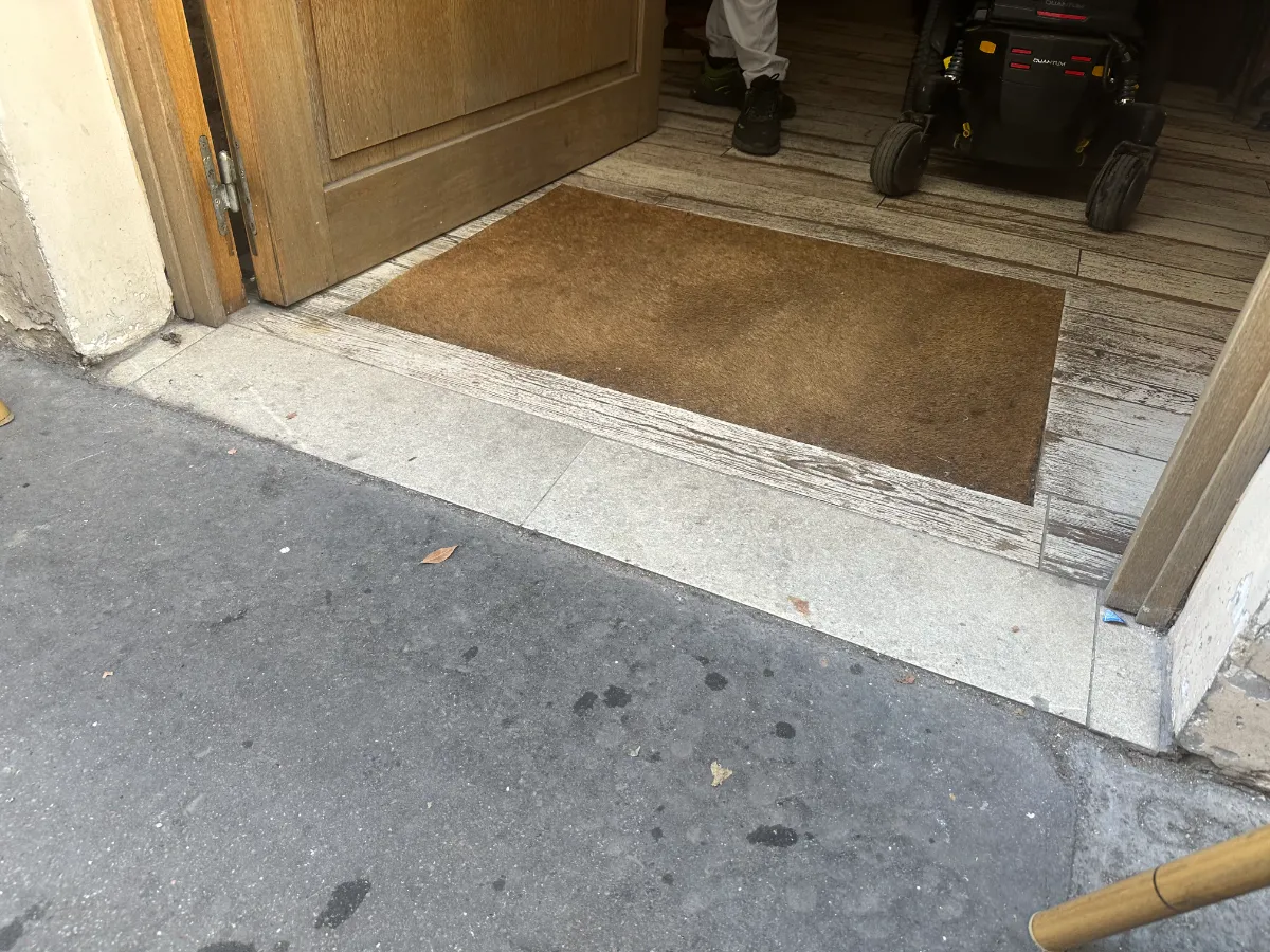 Entrance to Kémia — step-free access from pavement with a wide manual door