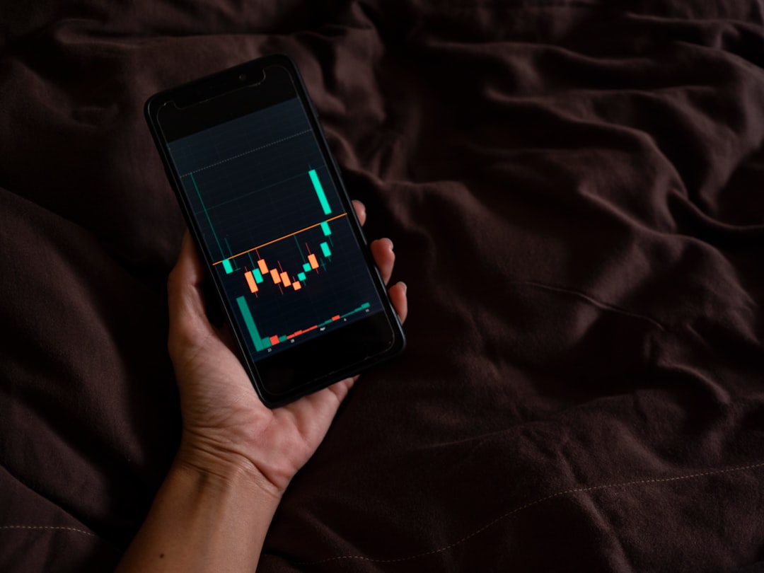 Person playing a stock market simulation game on their phone - Gamified Financial Literacy Person playing a stock market simulation game on their phone - Gamified Financial Literacy