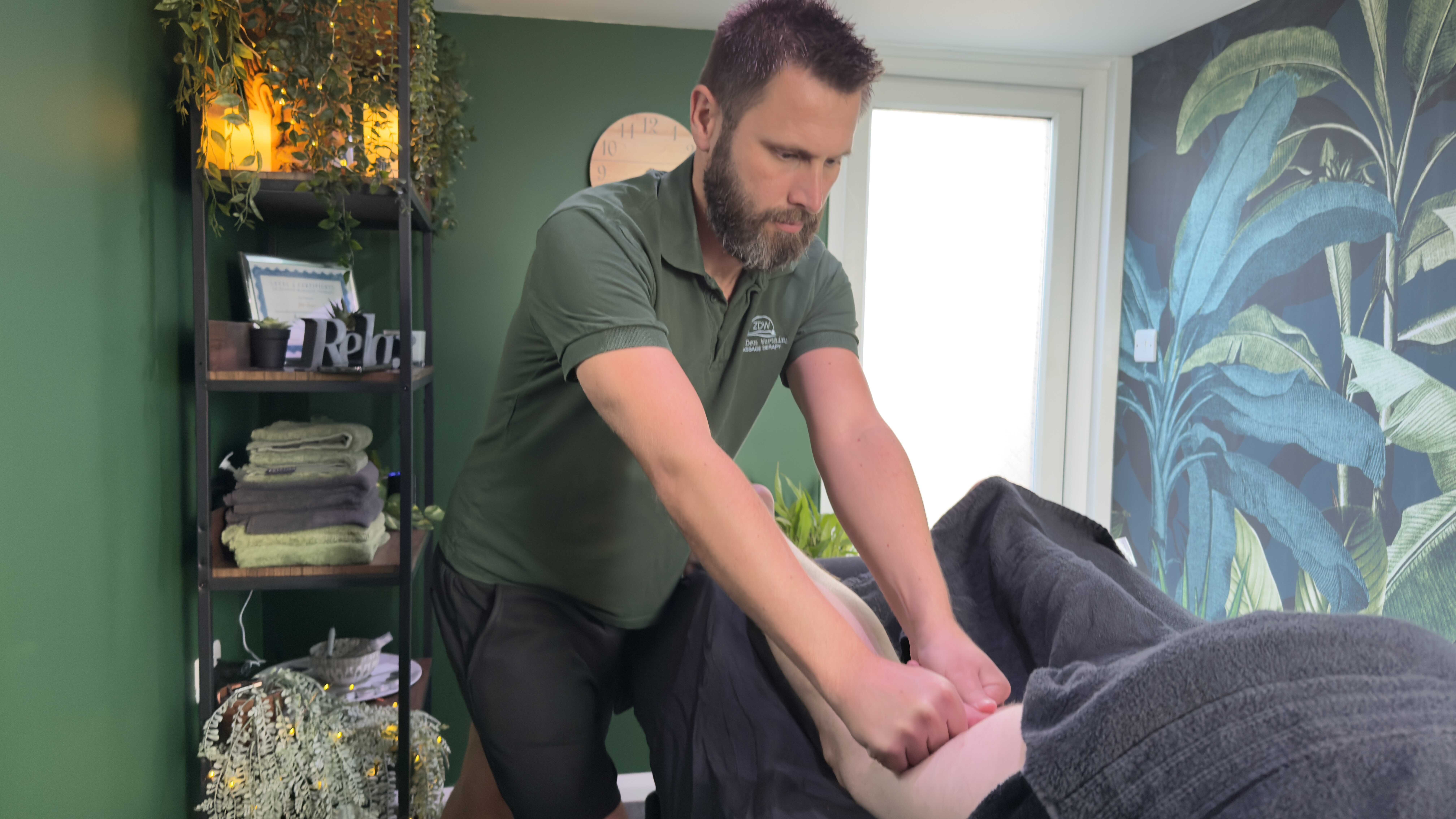 A massage therapist at Zen Den Worthing provides a professional sports massage focused on improving range of motion and flexibility, using targeted techniques to support pain relief, muscle relaxation, and injury recovery in a calming treatment room. This local massage therapy clinic in Worthing offers tailored sessions for enhanced wellbeing, increased mobility, and stress reduction, making it a top choice for those seeking the best massage therapy in West Sussex. The tranquil setting, with neatly arranged towels and relaxing decor, reflects Zen Den’s commitment to holistic wellness and therapeutic massage services in Worthing