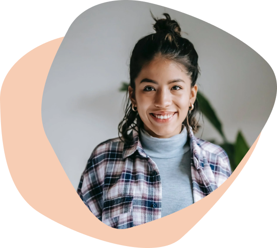 Brunette teen girl in turtleneck sweater and flannel and hair in a bun smiling