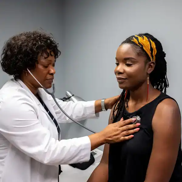 Doctor listening to patient's heartbeat with a stethoscope in doctors office