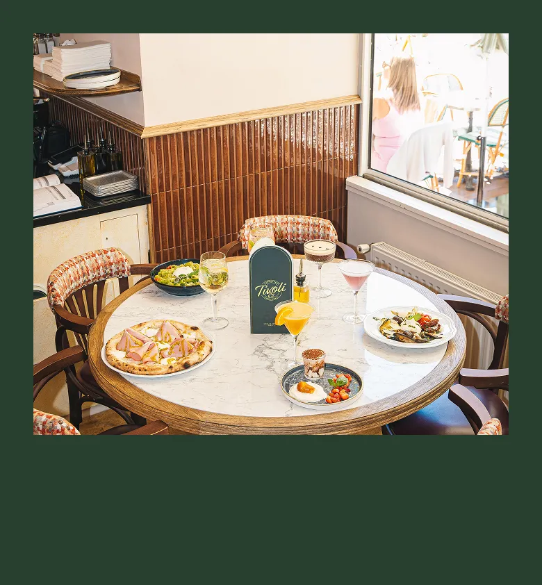 Coin repas intérieur chaleureux avec chaises en bois et assiettes de petit-déjeuner chez Tivoli