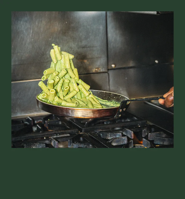 Chef cuisinant des pâtes fraîches à la flamme dans la cuisine du restaurant Tivoli