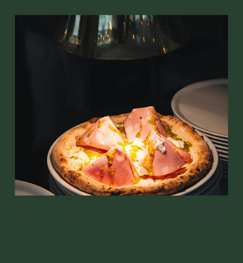 Pizza italienne cuite au four avec fromage fondant servie chaude au restaurant Tivoli