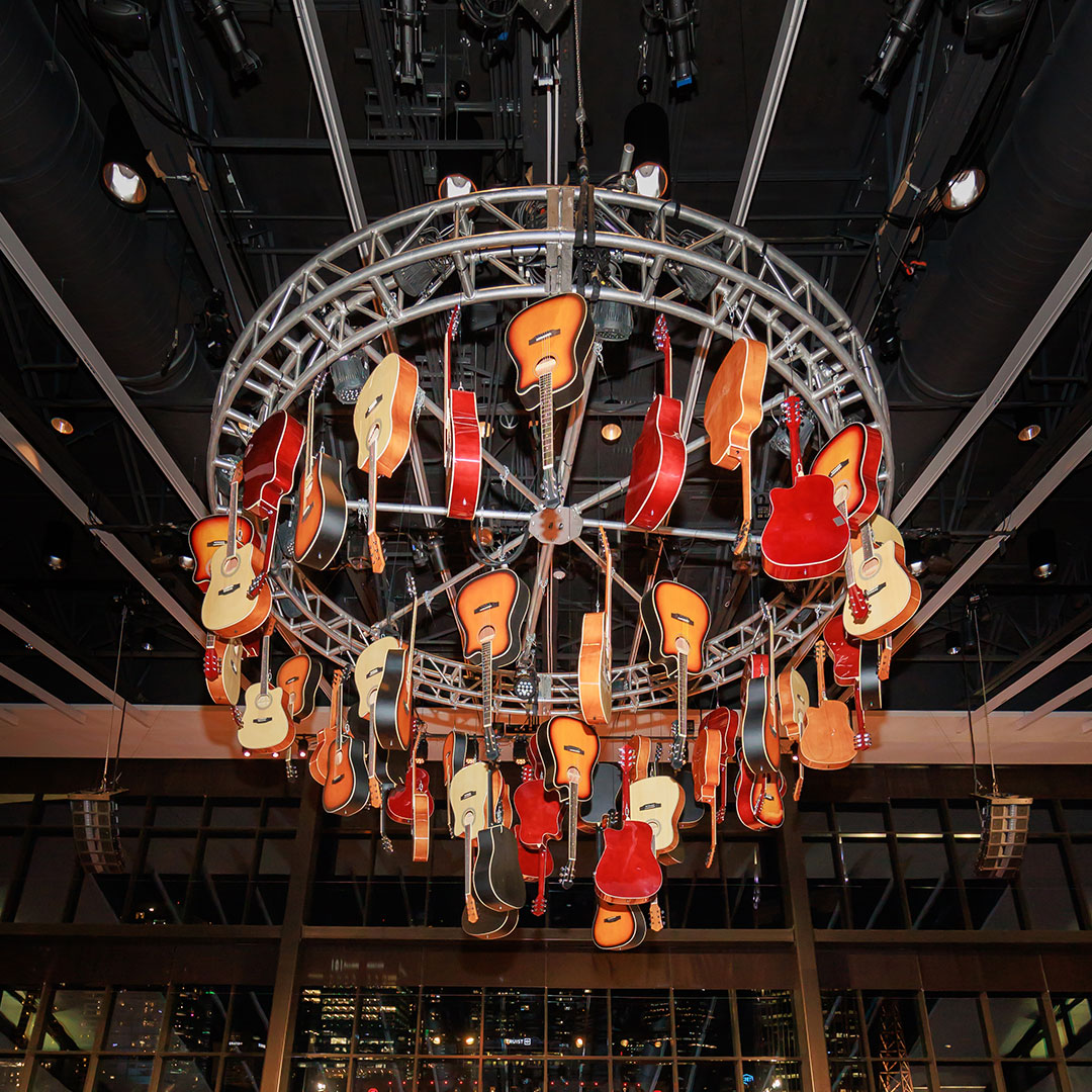a chandelier made up of hanging acoustic guitars