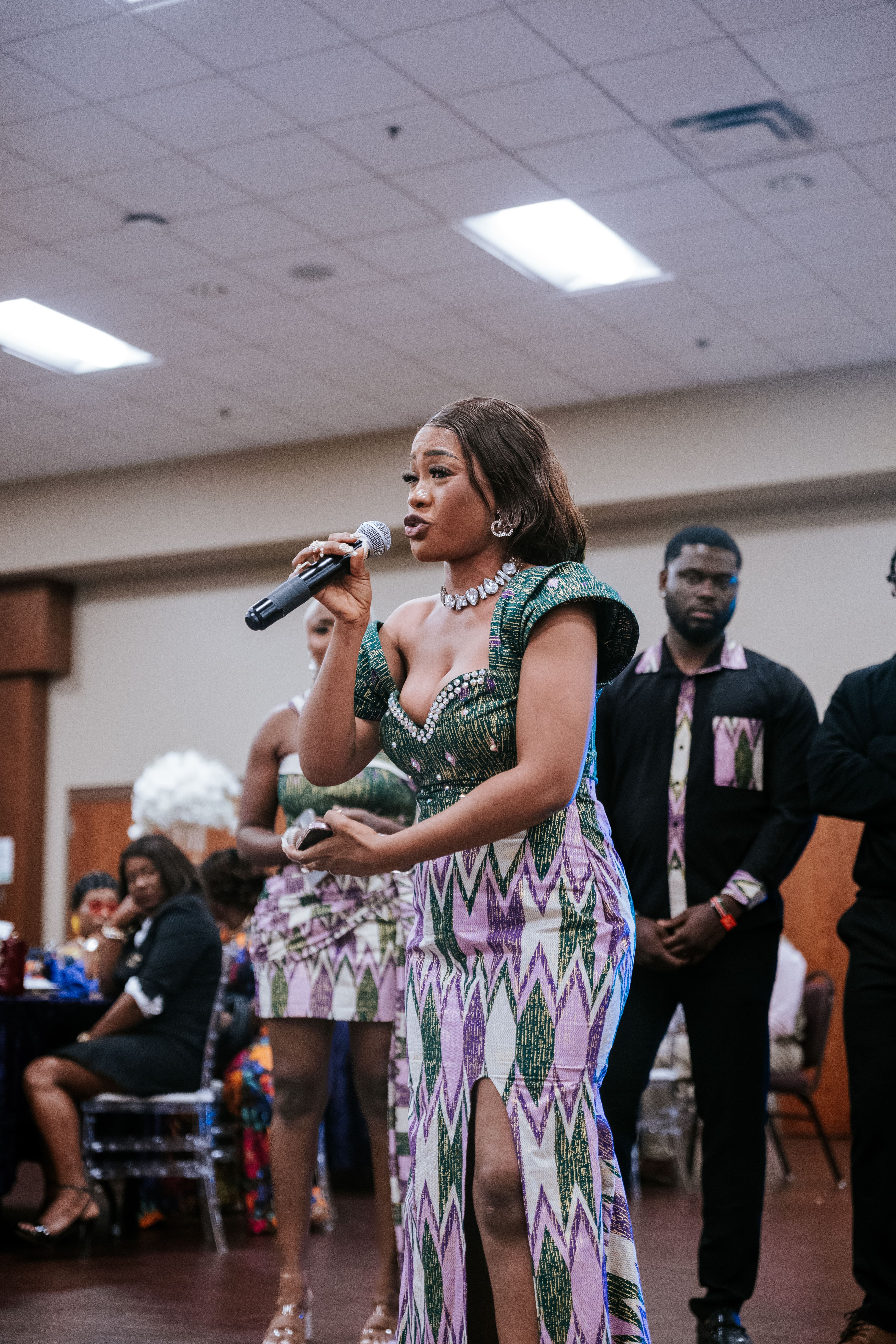 Burnsville, MN event photography by Faux Creative: Woman speaking into a microphone at a vibrant birthday party or celebration.