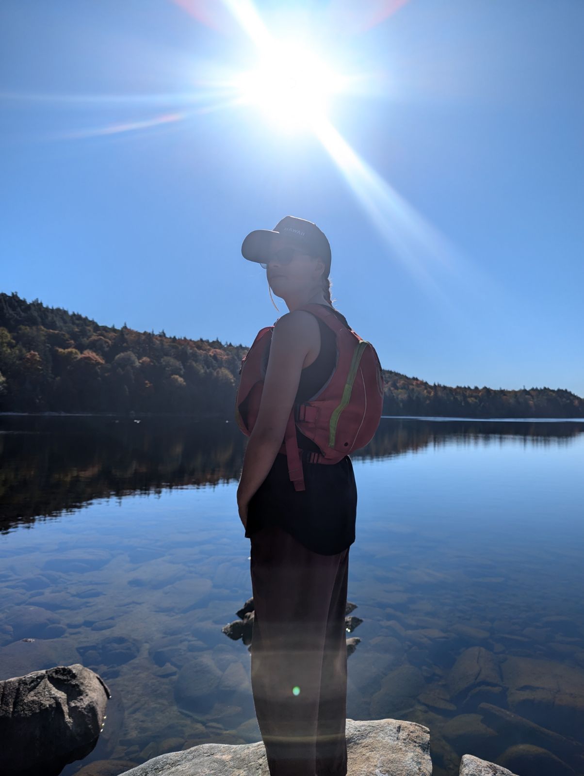 A girl stands at a vista over the water
