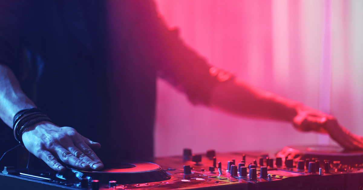 Un DJ joue des morceaux sur un mixeur, captivant le public avec ses sons dynamiques.