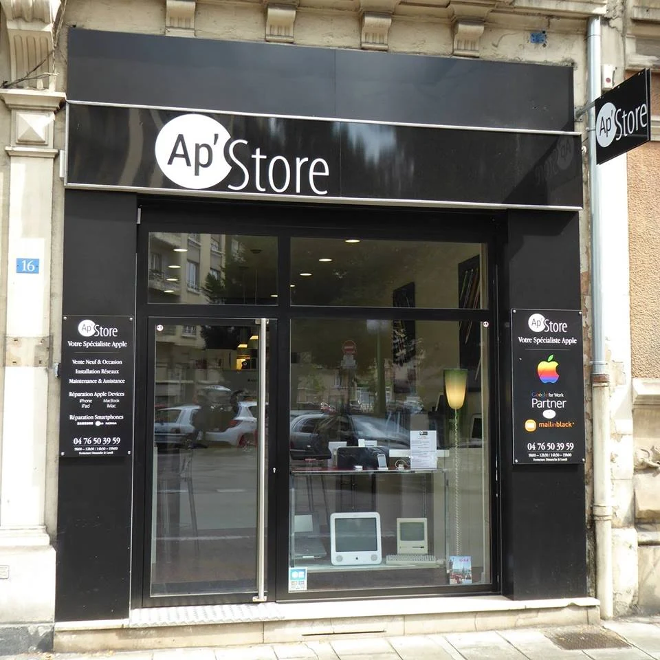 Facade of Ap' Store specializing in Apple products with black signage and display window showing vintage Apple computers inside.