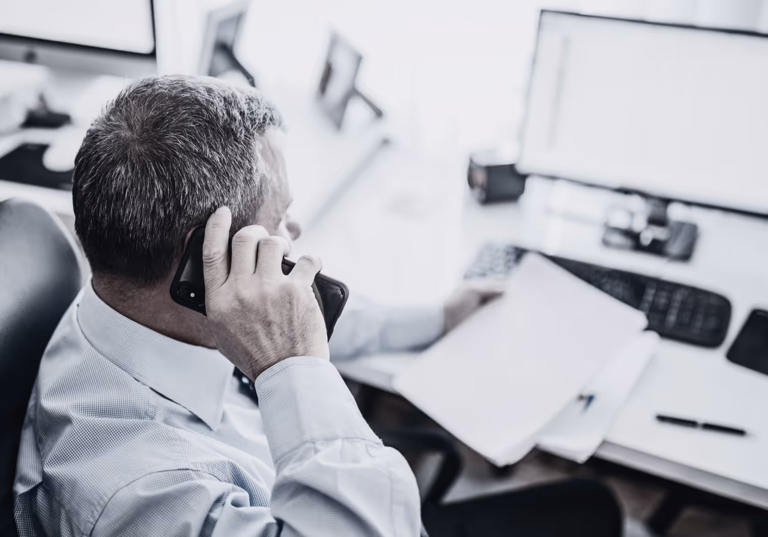 Man sitting at desk talking on the phone