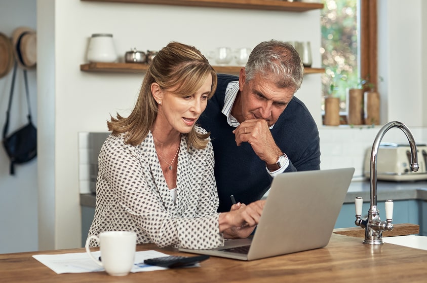 Senior couple planning finances together on a laptop at home