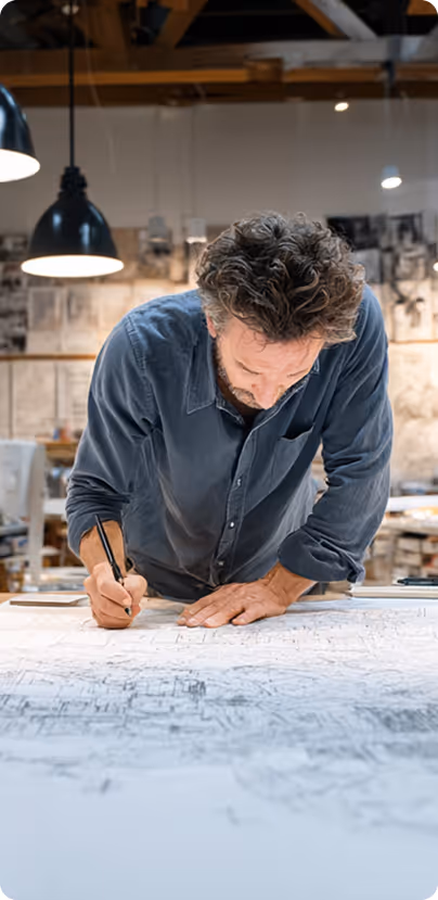 Homme géomètre en pleine analyse d’un plan topographique, concentré sur les mesures et relevés, illustrant la précision et la rigueur du métier.