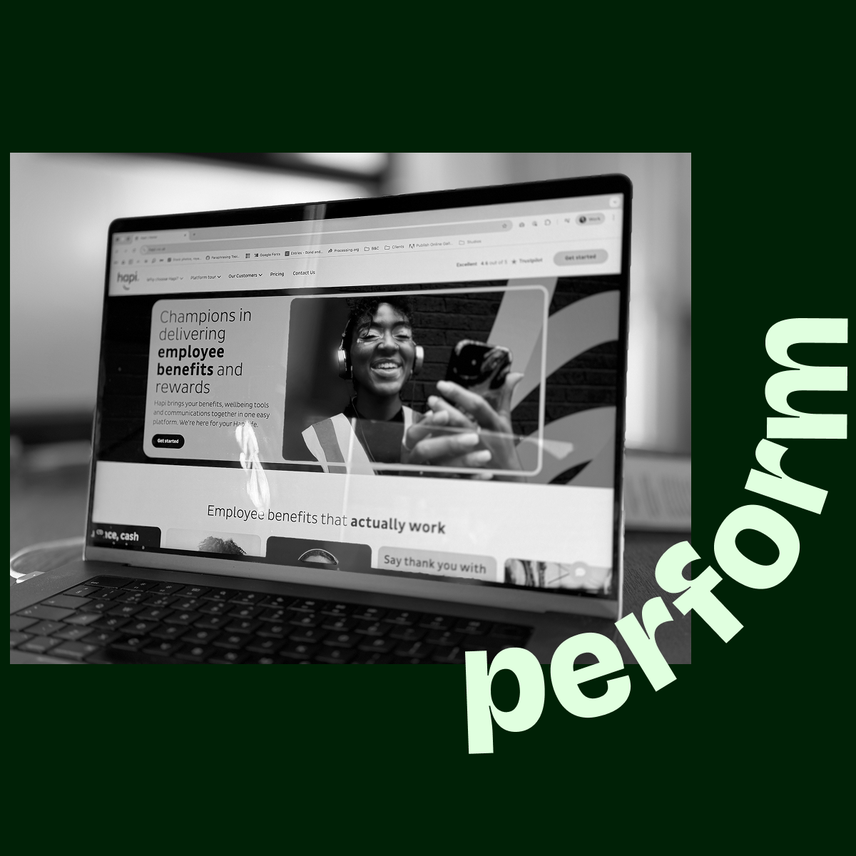 Laptop screen displaying a website about employee benefits and rewards with a smiling person wearing headphones holding a smartphone.