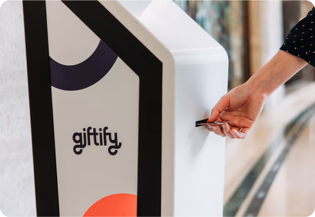 A person receiving a new gift card from a Giftify vending machine.