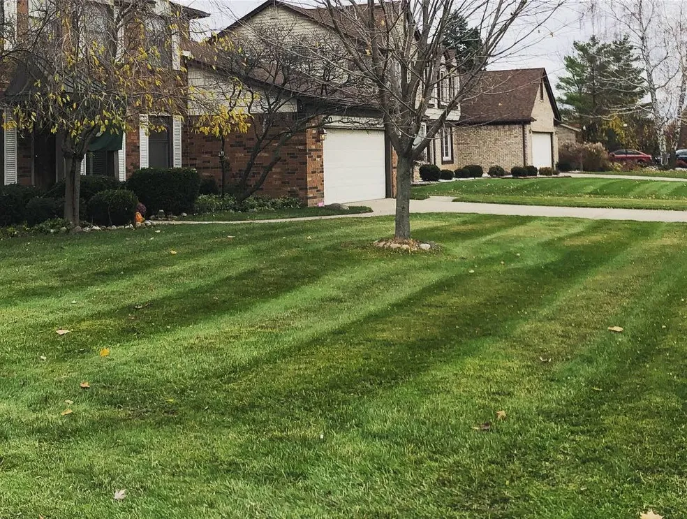 Professional lawn mowing service with perfect striping pattern by Jake's Lawn Care in Michigan residential neighborhood