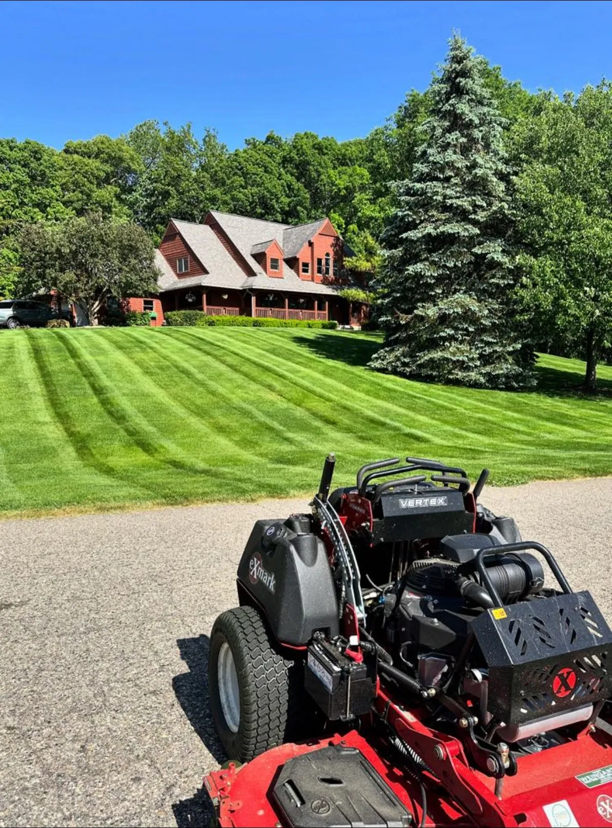 Commercial-grade lawn mowing equipment and pristine striped lawn maintenance by Jake's Lawn Care