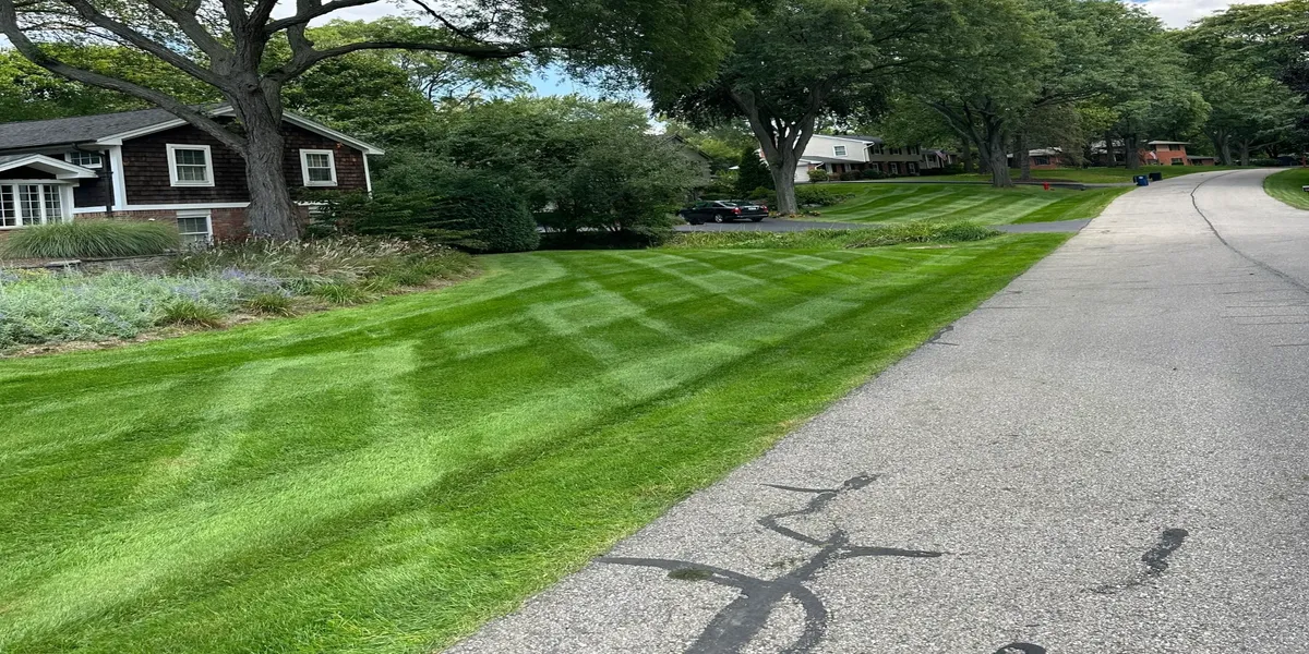 Professional lawn care service with perfect mowing patterns on Michigan residential property
