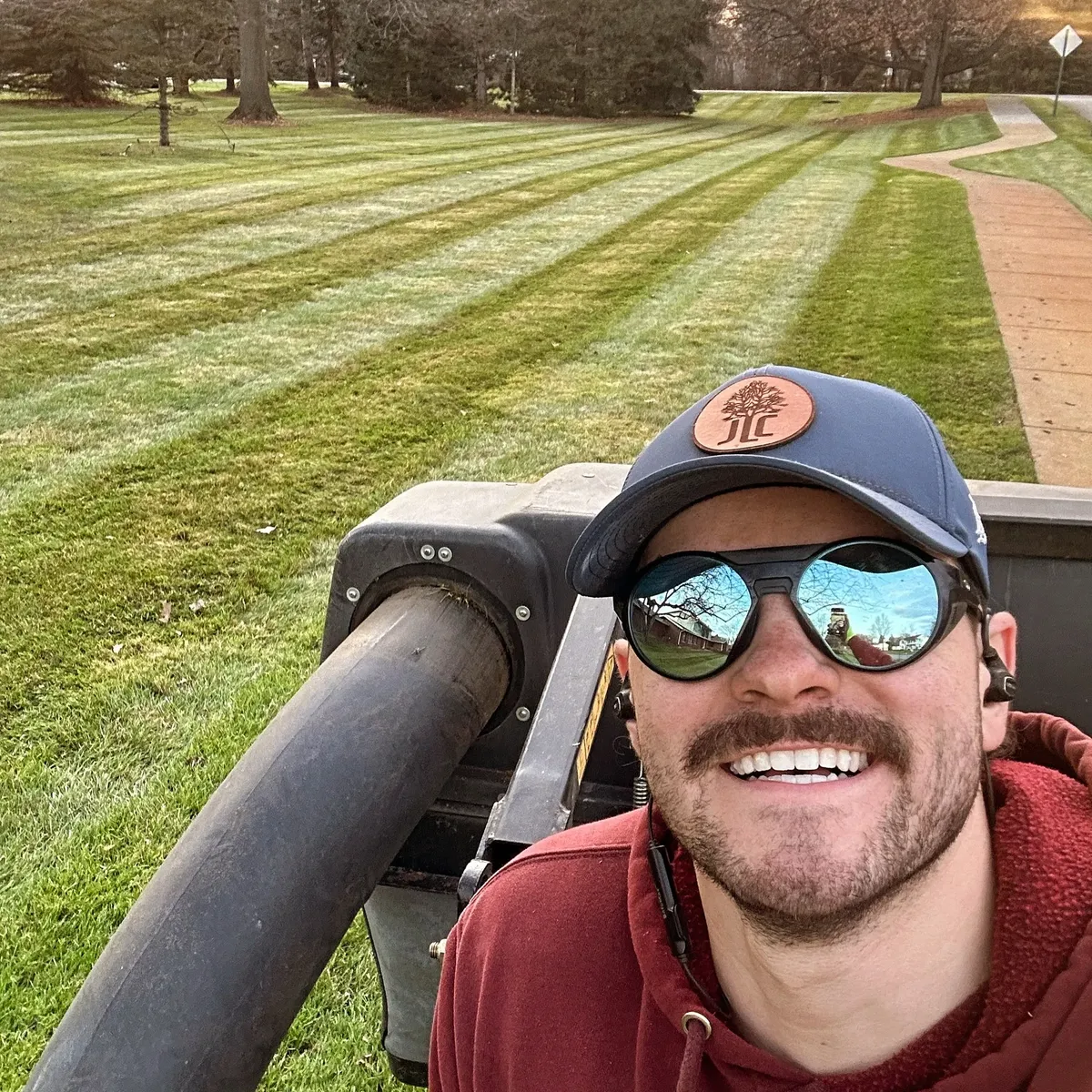 Jake Meissner owner of Jake's Lawn Care on commercial mowing equipment with perfectly striped lawn