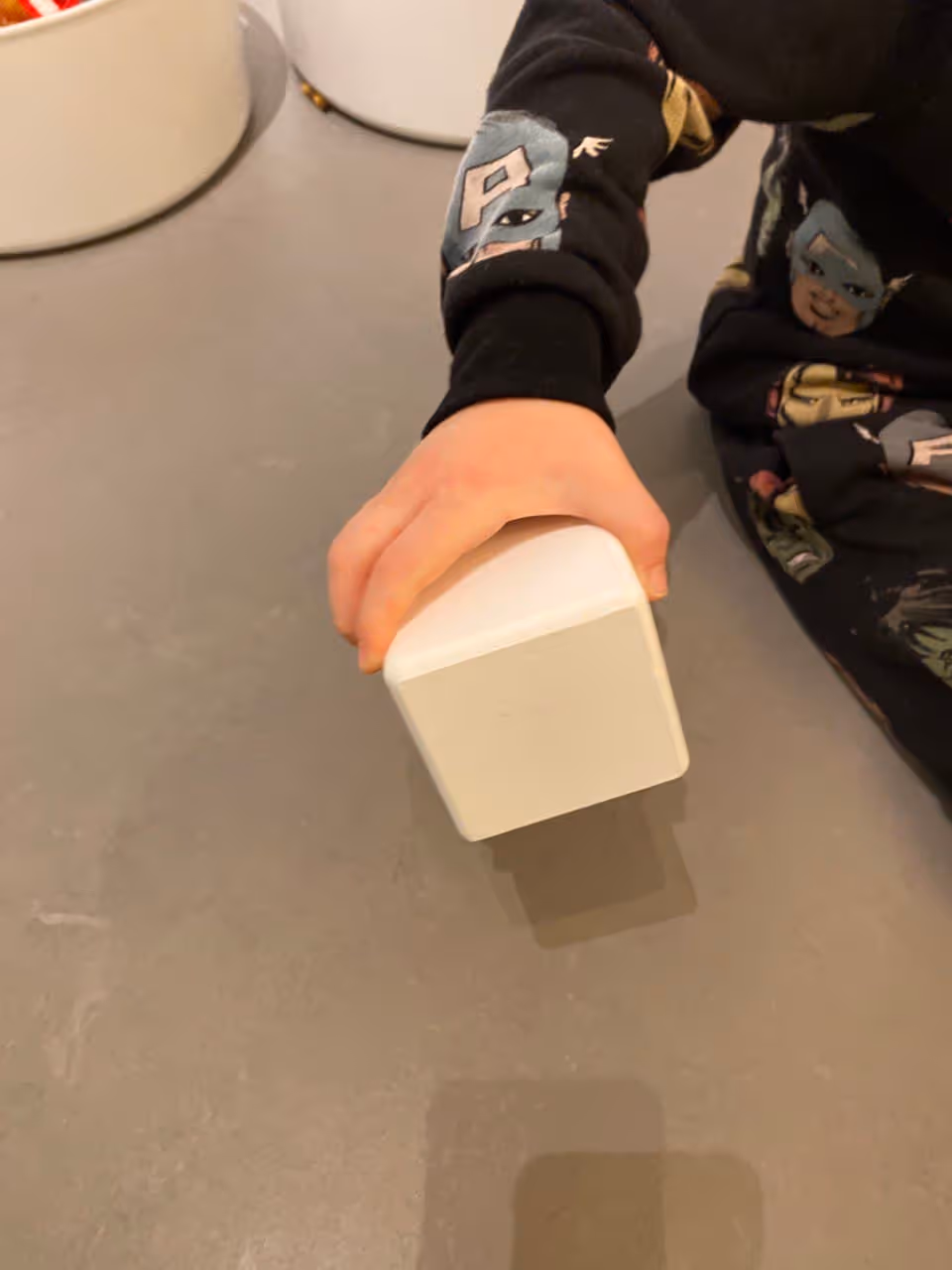 A picture of a kid holding one of the testing box sizes, size 7cm.