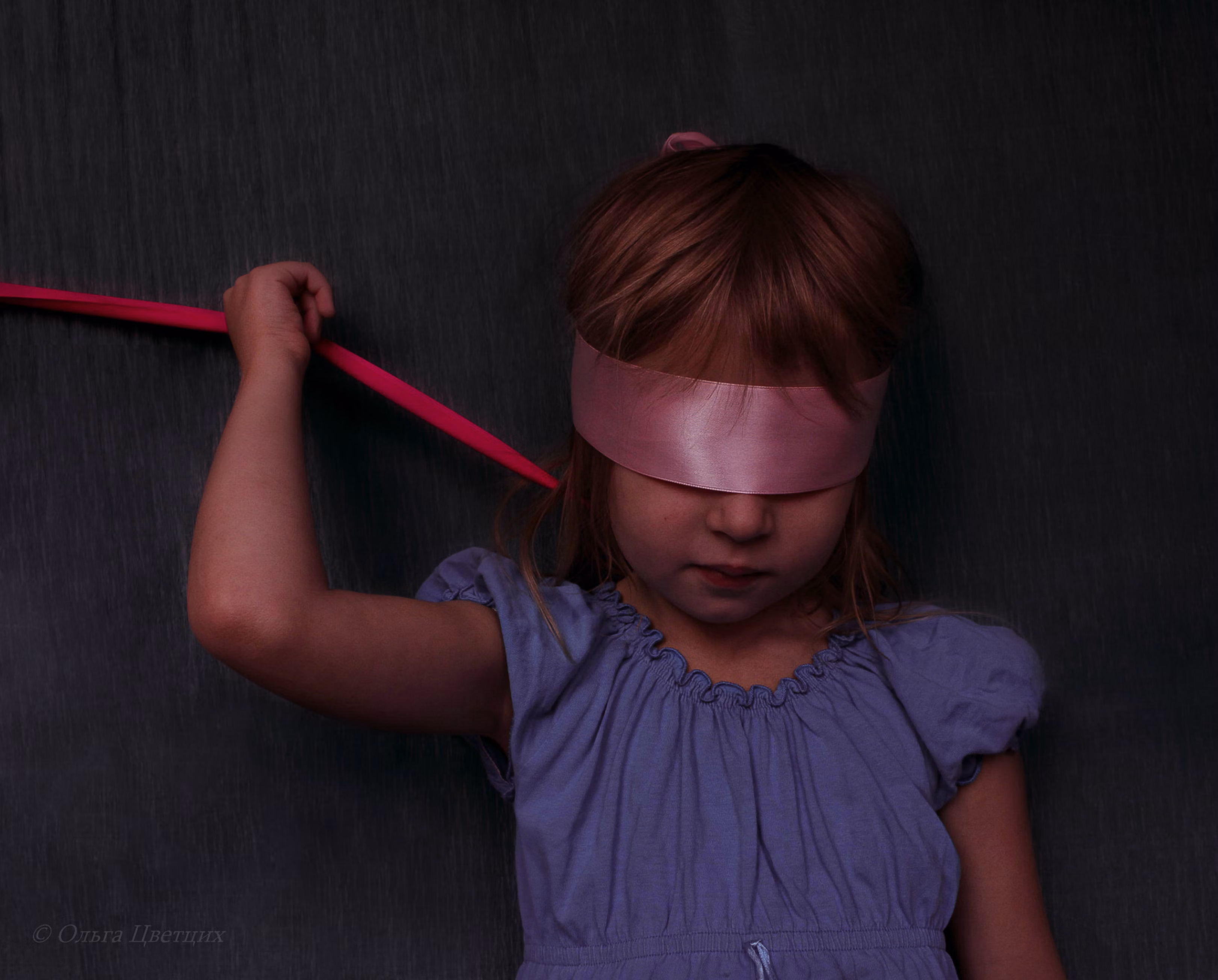 A photo of a child with a blindfold, illustrating how they might feel darkness.