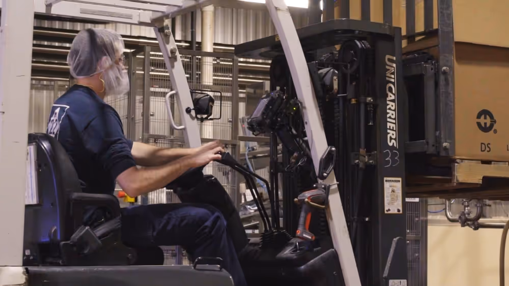 Team member driving forklift