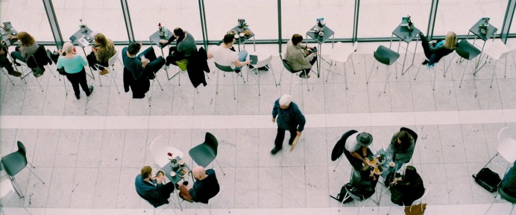 people sitting at small dining tables in a corporate cafeteria