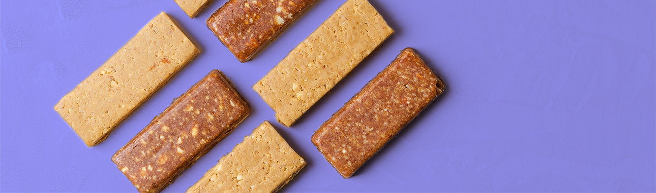 two flavors of protein bars on a purple background.