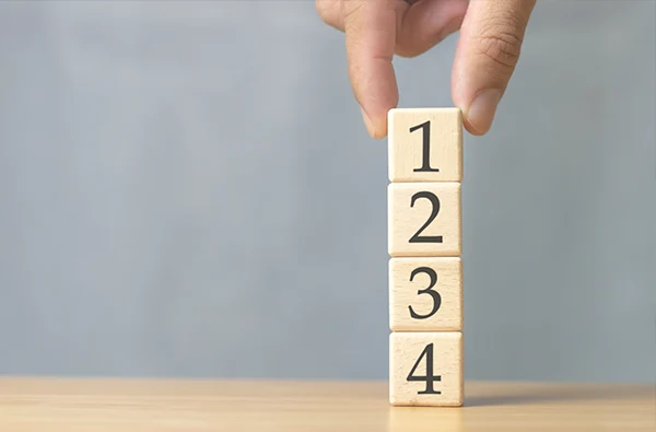 a close up photo of four numbered blocks stacked on top of each other on a table