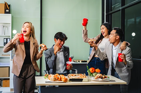 office colleagues and friends enjoy a daytime BBQ with pizza and beer, celebrating Halloween and cheering for their favorite soccer team, creating a lively atmosphere filled with joy