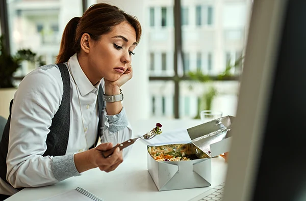 Bored businesswoman having lunch break while working in the office