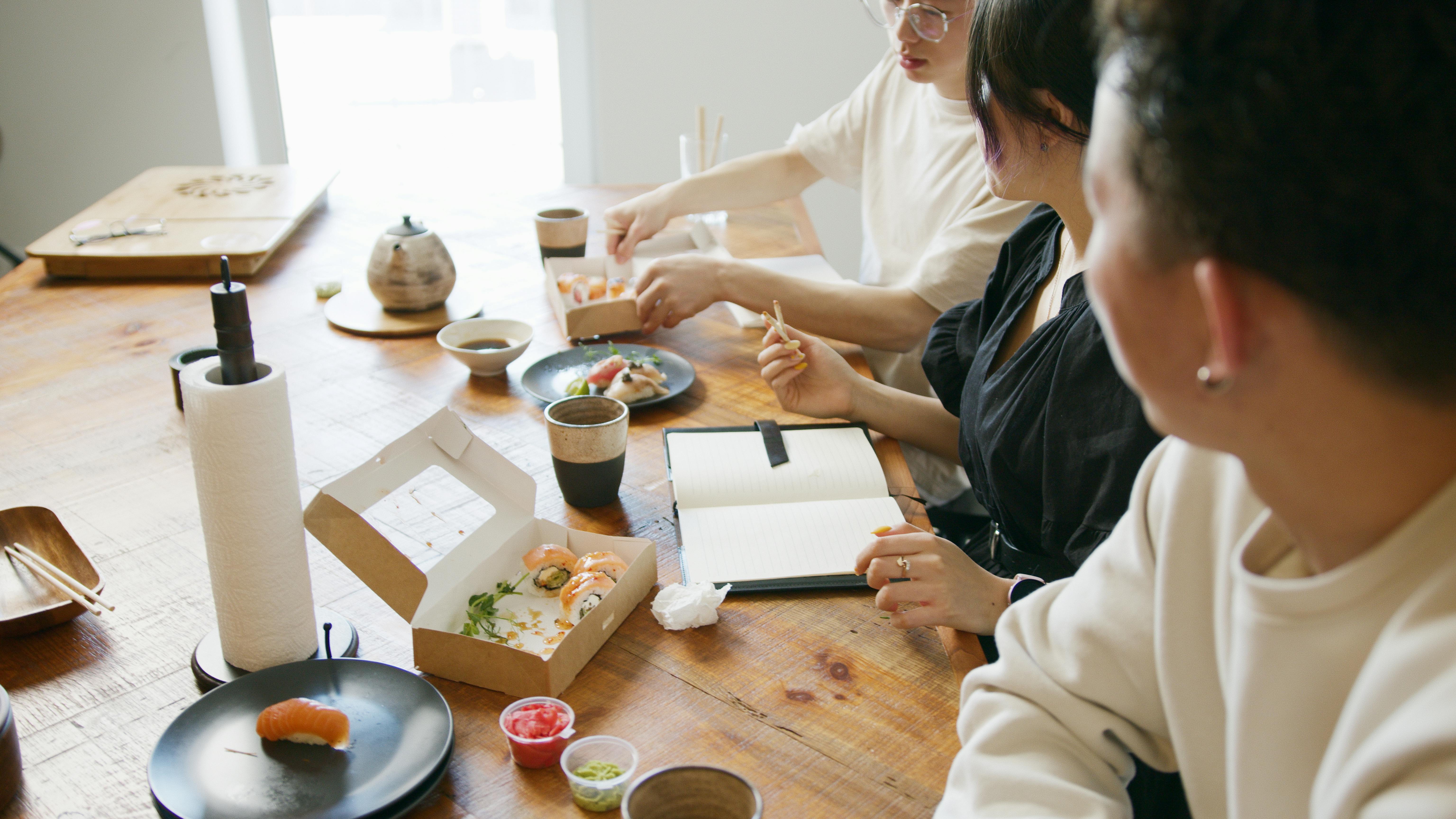 Employees eating a sushi lunch together