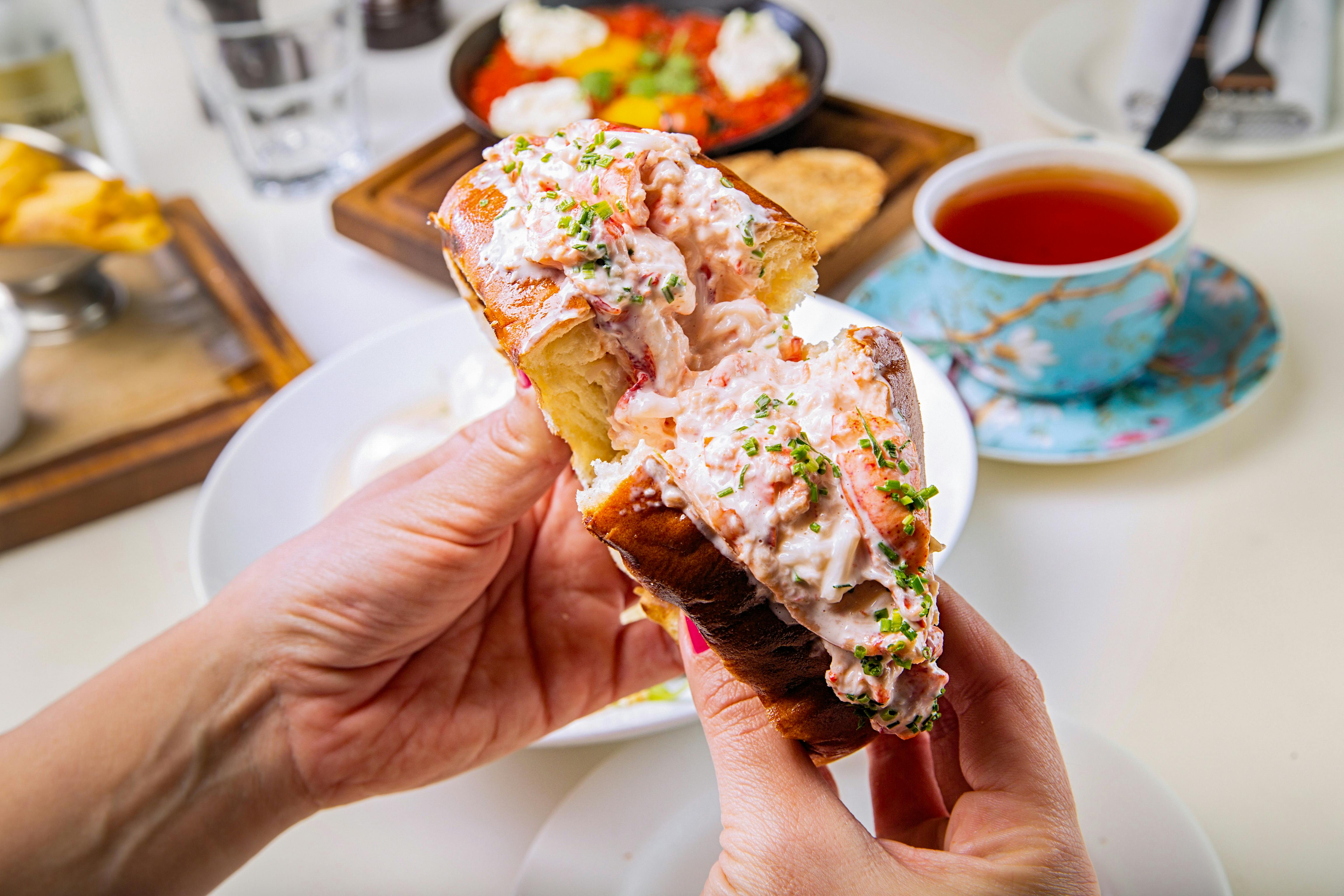 Someone holding a lobster roll cut in half