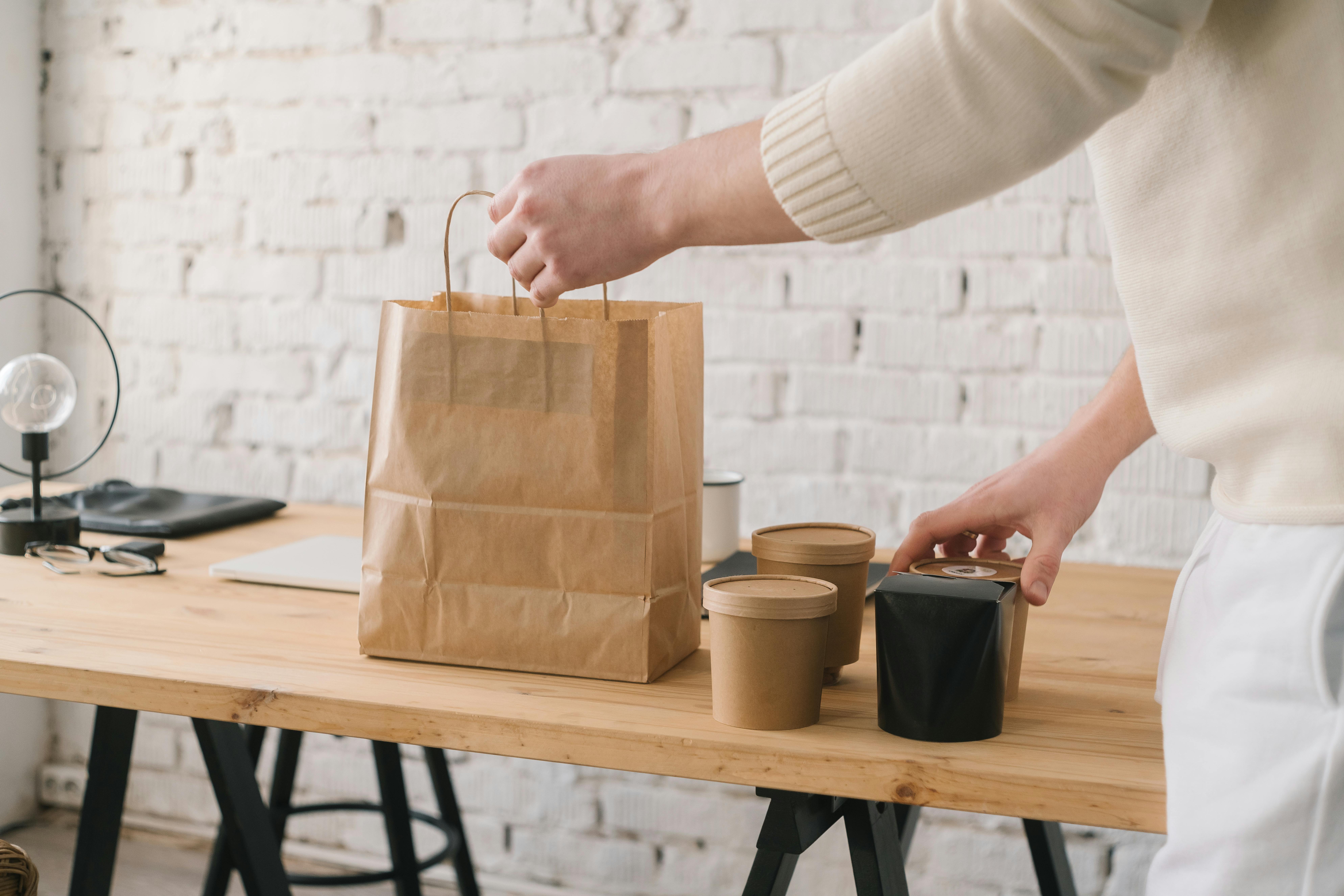 Person grabbing lunch bag packed with sustainable packaging