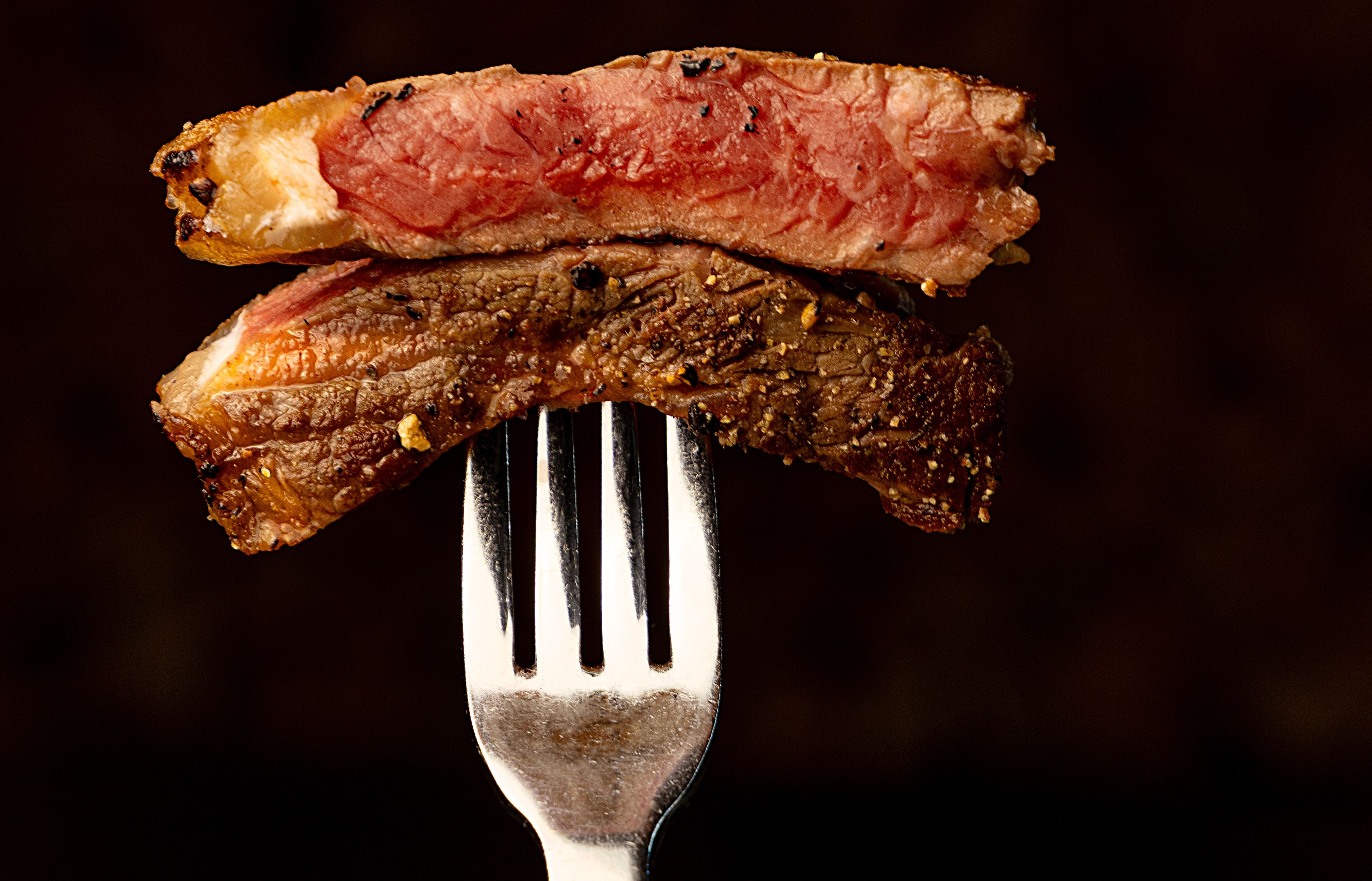 Two pieces of steak on a fork
