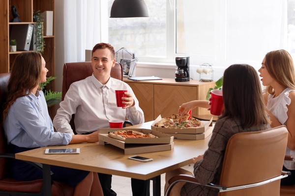 people eating pizza together at work