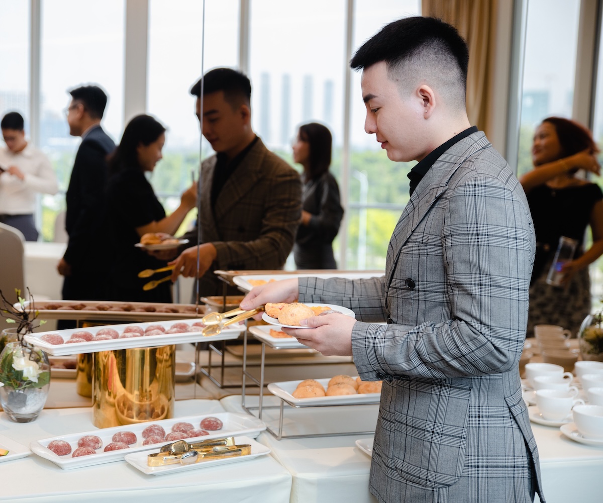 Employee going through line and getting food from catering buffet