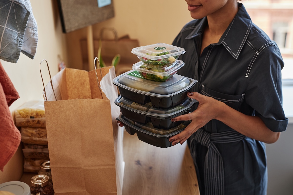 Employee opening lunch delivery bag