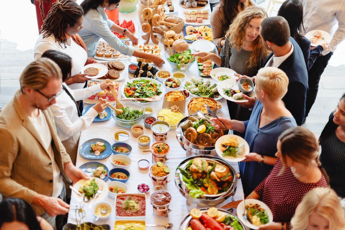 Employees getting food from a corporate catering spread