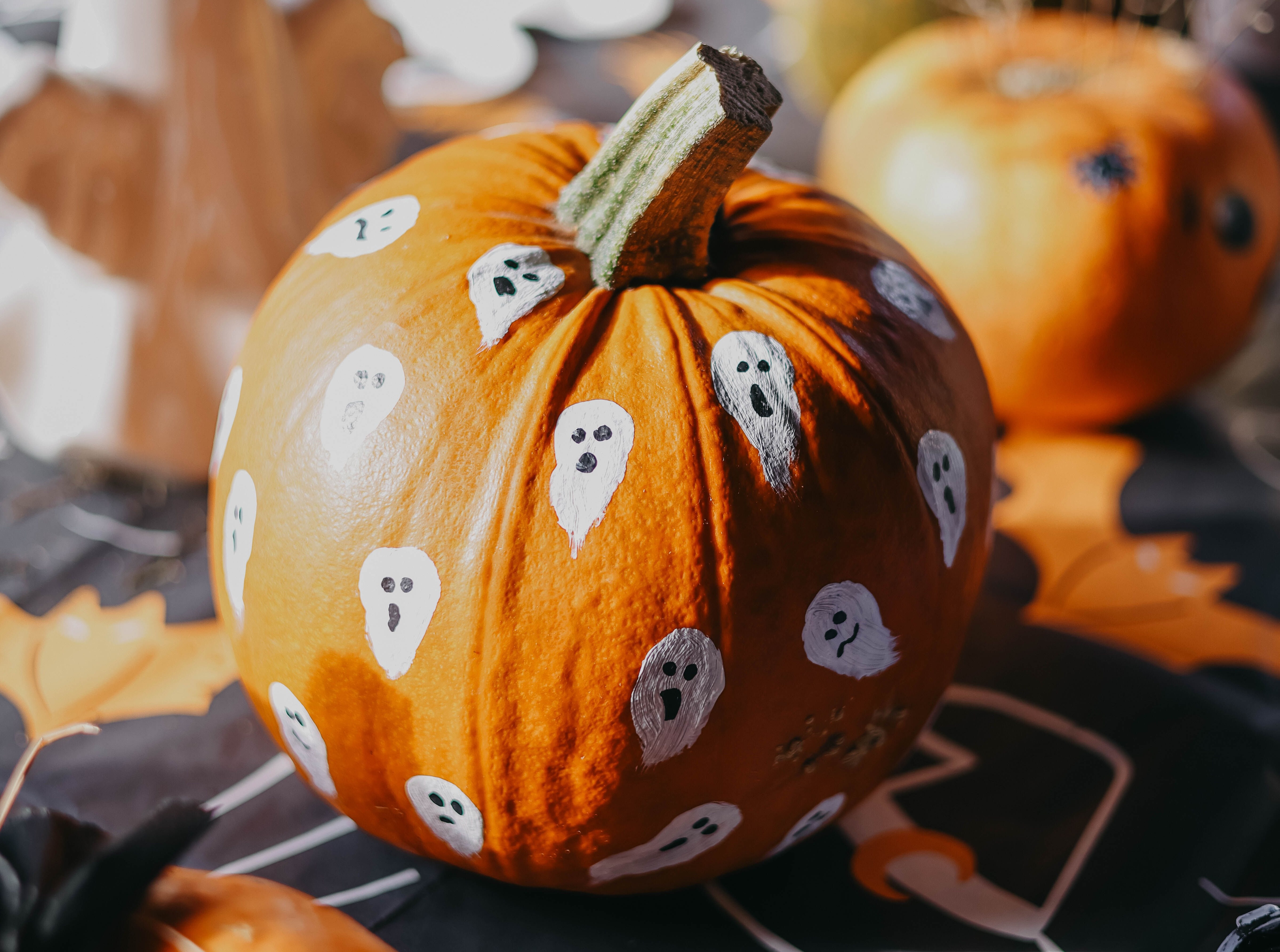 Pumpkin with ghosts painted on it