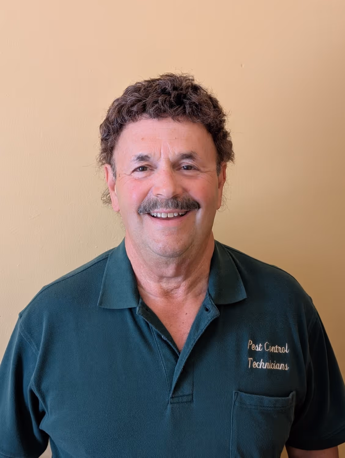 Author's photo: Joe Silvestrini, founder of Pest Control Technicians Inc., smiling in a green company polo shirt.