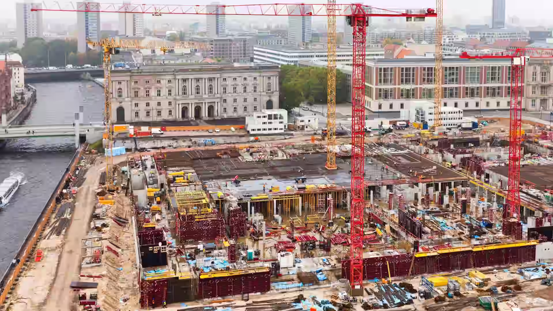 Construction site with multiple heavy machinery including cranes