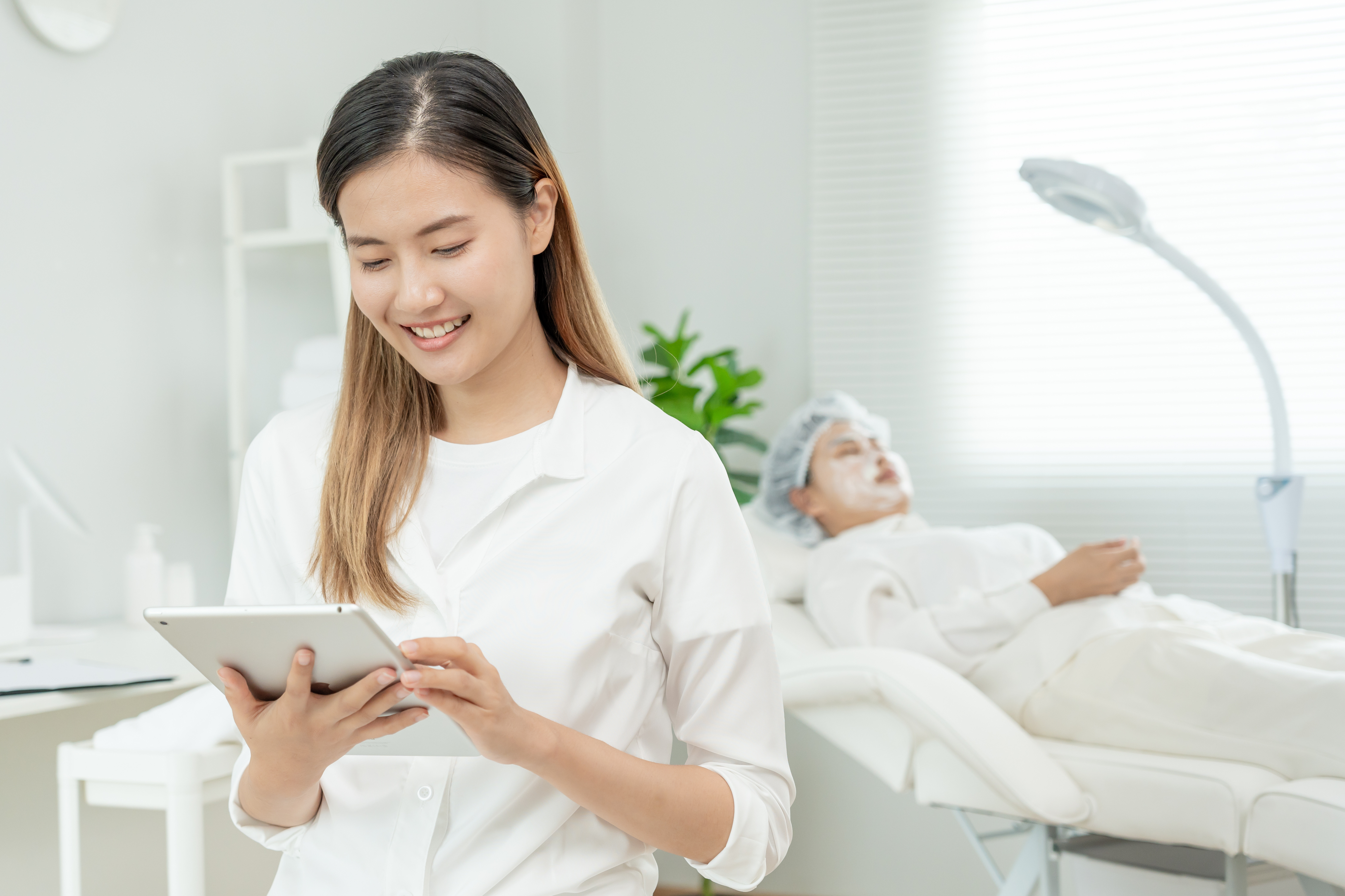 Spa receptionist using smart scheduling software to manage luxury spa appointments