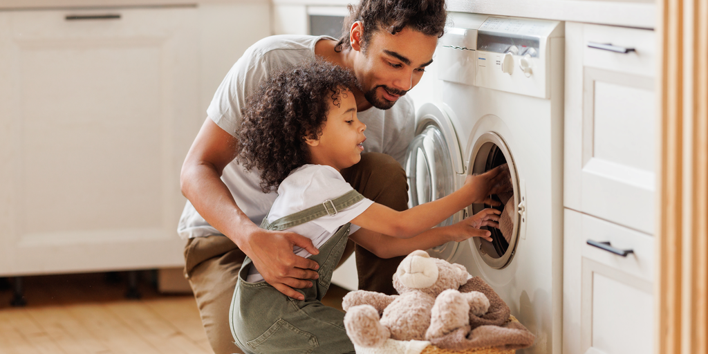 Un apà sta facendo la lavatrice con il figlio