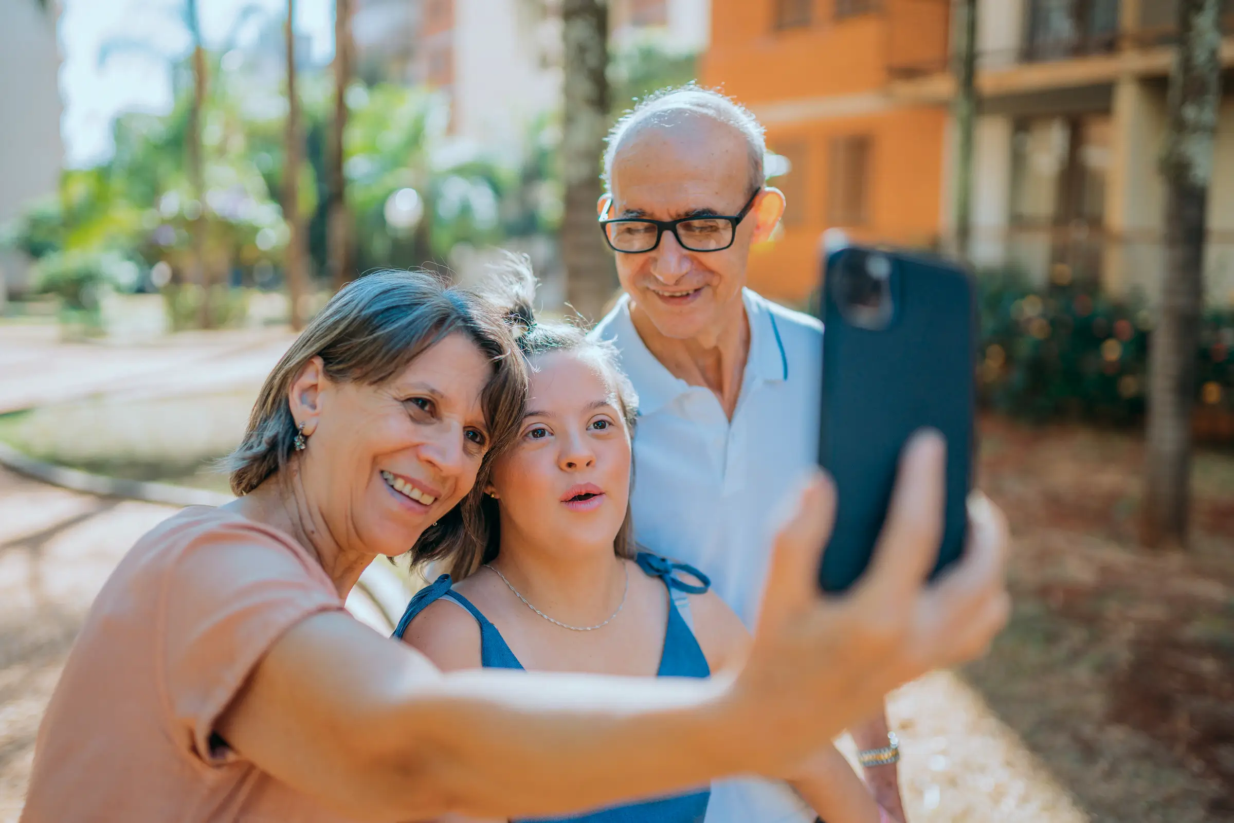 Family stands together to take a selfie photo of the fun they are having. 