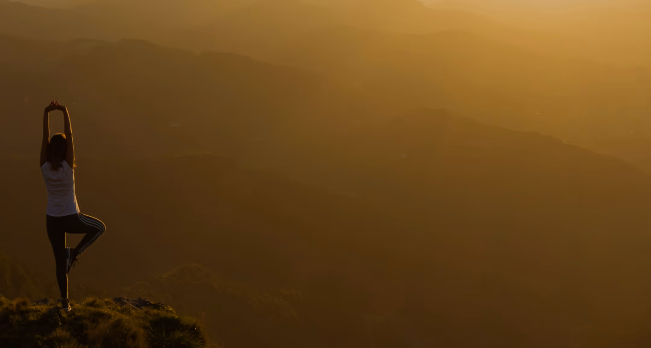 woman doing yoga on a mountain top