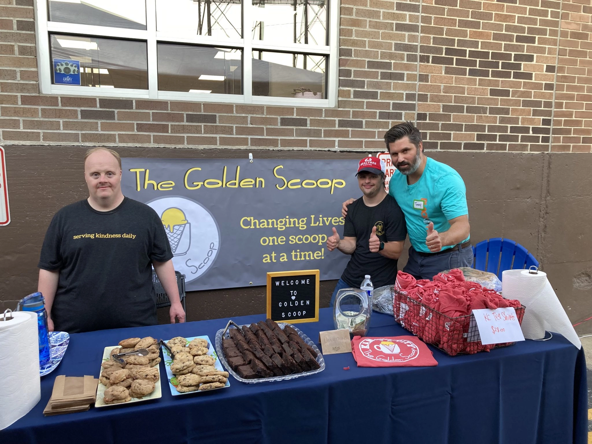 Photo of people standing around table with treats